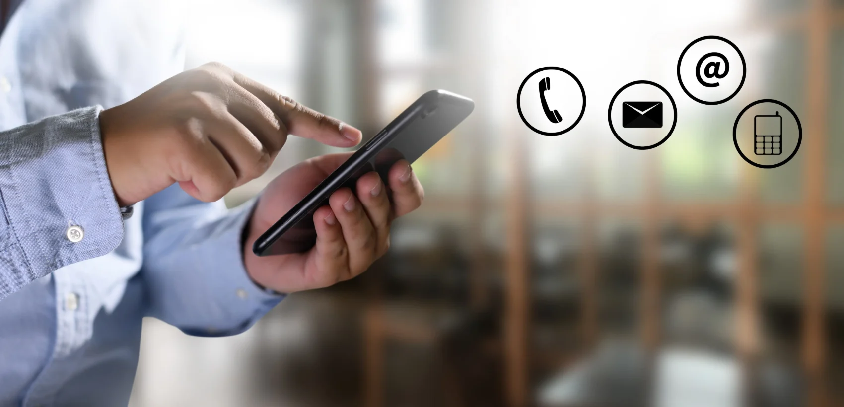 A person holding a phone with call, message and email icons, representing ways to make contact